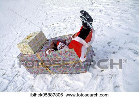 Stock Photograph - Misadventure, Christmas, Santa Claus falls into the gift box, Berlin, Germany, Europe. Fotosearch