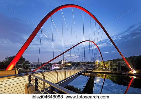 Modern red steel arched bridge over the Rhine-Herne-Canal, Twilight, Nordsternpark, Gelsenkirchen, Ruhr Area, North Rhine-Westphalia, Germany, Europe View Large Photo Image Stock Photo - Modern red steel arched bridge over the Rhine-Herne-Canal, Twilight, Nordsternpark, Gelsenkirchen, Ruhr Area, North Rhine-Westphalia, Germany, Europe. Fotosearch