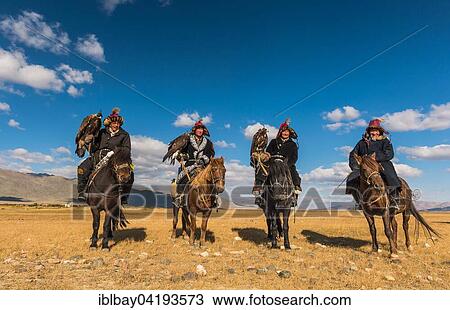 Stock Image - Mongolian eagle hunters on horses in the desert, Mongolia, Asia. Fotosearch