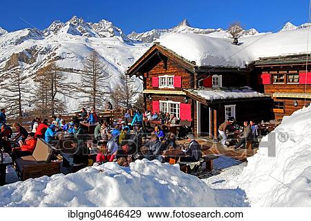 Stock Photo - Mountain inn with sun terrace in winter on Riffelalp 2222m, in the back Obergabelhorn 4063m and Zinalrothorn 4221m, Zermatt, Mattertal, Valais, Switzerland, Europe. Fotosearch