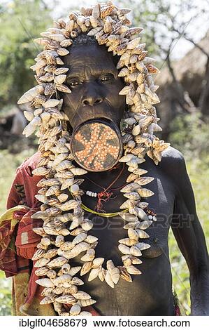 Old woman with lip plates and shells as headdress, portrait, tribe of the Mursi, Southern Nations Nationalities and Peoples' Region, Ethiopia, Africa View Large Photo Image Stock Photo - Old woman with lip plates and shells as headdress, portrait, tribe of the Mursi, Southern Nations Nationalities and Peoples' Region, Ethiopia, Africa. Fotosearch