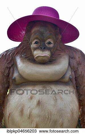 Stock Image - Orang Utan figure with purple sunhat, Nong Nooch Tropical Botanical Garden, Pattaya, Thailand, Asia. Fotosearch
