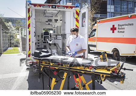 Stock Image - Paramedic cleans stretcher in front of Agatharied hospital, Bavaria, Germany, Europe. Fotosearch