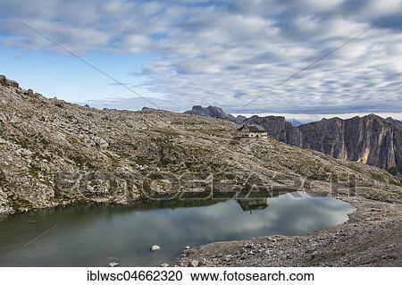 Stock Image - Pisciadù hut, with water reflection in Pisciadù lake, northern Sella group, Dolomites, South Tyrol, Italy, Europe. Fotosearch