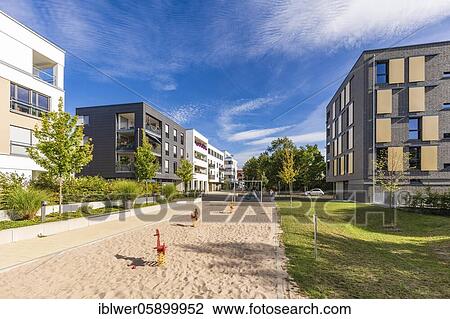 Stock Image - Playground in front of modern apartment building, residential house, sandpit, Tübingen, Baden-Württemberg, Germany, Europe. Fotosearch