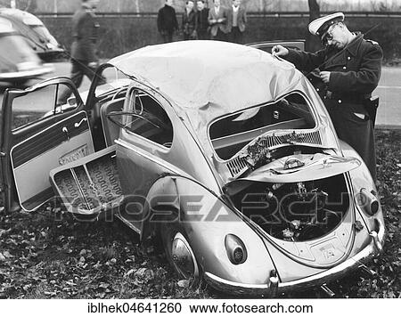 Stock Image - Police officer inspects VW beetle with total damage, 1960s, Berlin, Germany, Europe. Fotosearch