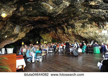 Stock Image - Polignano al Mare, restaurant built in natural cave, Grotta Palazzese Polignano al Mare, Apulia, Italy, Europe. Fotosearch