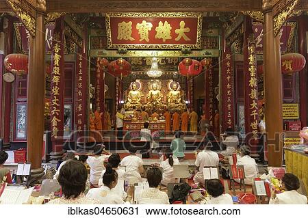 Stock Image - Prayer hall with Buddhist monks and believers, Wat Mangkon Kamalawat, Chinese Buddhist temple, Pom Prap Sattru Phai, Bangkok, Thailand, Asia. Fotosearch