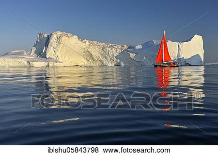Stock Photo - Red sailing boat in front of icebergs, Icefjord, UNESCO World Heritage, Disko Bay, Ilulissat, West Greenland, Greenland, North America. Fotosearch