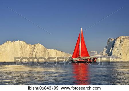 Stock Photo - Red sailing boat in front of icebergs, Icefjord, UNESCO World Heritage, Disko Bay, Ilulissat, West Greenland, Greenland, North America. Fotosearch