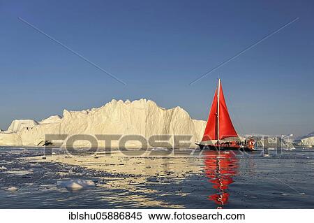 Stock Photography - Red sailing boat in front of icebergs, Icefjord, UNESCO World Heritage, Disko Bay, Ilulissat, West Greenland, Greenland, North America. Fotosearch