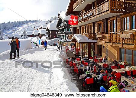 Stock Photo - Restaurant terrace on the Dorfstrasse with snow-covered houses, Bettmeralp, Aletsch area, Upper Valais, Valais, Switzerland, Europe. Fotosearch