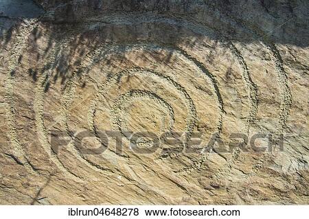 Stock Photo - Rock engraving on Neolithic passage grave, Knowth, Unesco world heritage sight, prehstoric Bru na Boinne, Ireland, Europe. Fotosearch