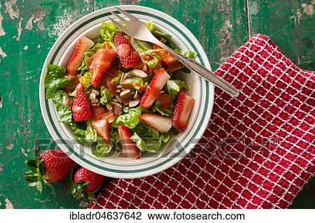 Stock Image - Salad with strawberries served in a plate, food still-life, studio shot. Fotosearch