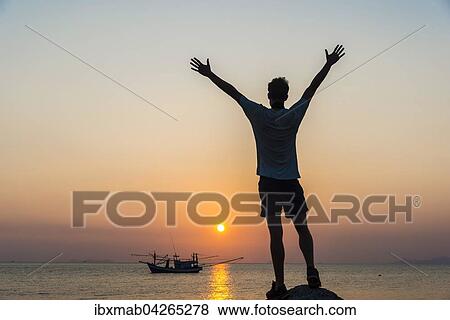 Silhouette eines jungen Mannes, Boot im Meer bei Sonnenuntergang, Insel Koh Samui, Golf von Thailand, Thailand, Asien View Large Photo Image Stock Photo - Silhouette eines jungen Mannes, Boot im Meer bei Sonnenuntergang, Insel Koh Samui, Golf von Thailand, Thailand, Asien. Fotosearch