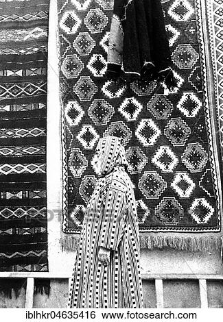 Stock Photograph - Similarity of carpet and clothes, between 50s and 60s, exact location unknown, France, Europe. Fotosearch