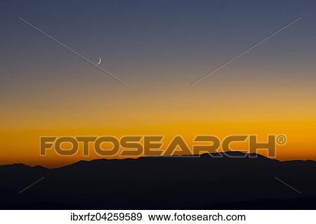 Stock Photo - Sonnenuntergang und Sichelmond uber den sibillinischen Bergen, Castelluccio di Norcia, Nationalpark Monti Sibillini, Parco nazionale dei Monti Sibillini, Umbrien, Italien, Europa. Fotosearch