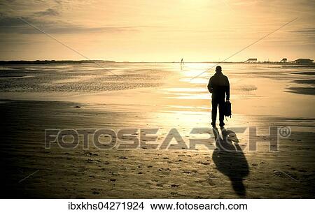 Spazierganger am Strand bei untergehender Sonne, Sankt Peter-Ording, Schleswig Holstein, Deutschland, Europa View Large Photo Image Picture - Spazierganger am Strand bei untergehender Sonne, Sankt Peter-Ording, Schleswig Holstein, Deutschland, Europa. Fotosearch