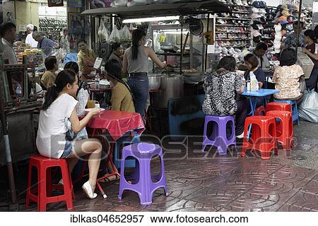 Stock Photo - Streetfood stand with colourful tables and chairs, Yaowarat Road, Chinatown, Samphanthawong, Bangkok, Thailand, Asia. Fotosearch