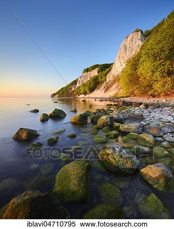 Sunrise at the Baltic Sea, chalk cliffs in the first morning light, boulders on the shore, in front the Königsstuhl, behind the Victoria view, Jasmund National Park, UNESCO World Heritage Site, Rügen Island, Mecklenburg-Western Pomerania, Germany, Europe View Large Photo Image Stock Photography - Sunrise at the Baltic Sea, chalk cliffs in the first morning light, boulders on the shore, in front the Königsstuhl, behind the Victoria view, Jasmund National Park, UNESCO World Heritage Site, Rügen Island, Mecklenburg-Western Pomerania, Germany, Europe. Fotosearch