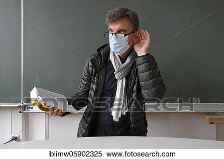 Teacher with a thick winter jacket, scarf and face mask in class, hand on ear, communication problems, corona crisis, Stuttgart, Baden-Württemberg, Germany, Europe View Large Photo Image Stock Photography - Teacher with a thick winter jacket, scarf and face mask in class, hand on ear, communication problems, corona crisis, Stuttgart, Baden-Württemberg, Germany, Europe. Fotosearch