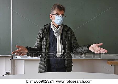 Teacher with thick winter jacket, scarf and face mask in classroom teaching, Corona crisis, Stuttgart, Baden-Württemberg, Germany, Europe View Large Photo Image Picture - Teacher with thick winter jacket, scarf and face mask in classroom teaching, Corona crisis, Stuttgart, Baden-Württemberg, Germany, Europe. Fotosearch