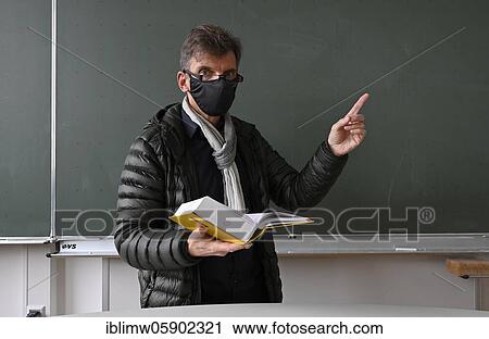 Teacher with thick winter jacket, scarf and face mask in classroom teaching, Corona crisis, Stuttgart, Baden-Württemberg, Germany, Europe View Large Photo Image Stock Image - Teacher with thick winter jacket, scarf and face mask in classroom teaching, Corona crisis, Stuttgart, Baden-Württemberg, Germany, Europe. Fotosearch