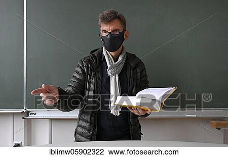 Teacher with thick winter jacket, scarf and face mask in classroom teaching, Corona crisis, Stuttgart, Baden-Württemberg, Germany, Europe View Large Photo Image Stock Image - Teacher with thick winter jacket, scarf and face mask in classroom teaching, Corona crisis, Stuttgart, Baden-Württemberg, Germany, Europe. Fotosearch