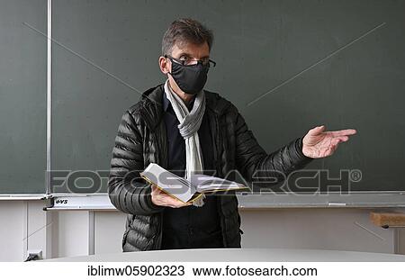 Teacher with thick winter jacket, scarf and face mask in classroom teaching, Corona crisis, Stuttgart, Baden-Württemberg, Germany, Europe View Large Photo Image Stock Image - Teacher with thick winter jacket, scarf and face mask in classroom teaching, Corona crisis, Stuttgart, Baden-Württemberg, Germany, Europe. Fotosearch