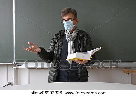 Teacher with thick winter jacket, scarf and face mask in classroom teaching, Corona crisis, Stuttgart, Baden-Württemberg, Germany, Europe View Large Photo Image Stock Photograph - Teacher with thick winter jacket, scarf and face mask in classroom teaching, Corona crisis, Stuttgart, Baden-Württemberg, Germany, Europe. Fotosearch