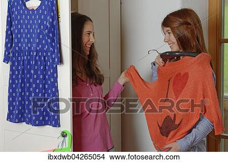 Picture - Teenager, Madchen, Freundinnen, wahlen Kleidung aus, stehen vorm Kleiderschrank Oberbayern Deutschland. Fotosearch