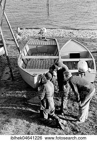 Stock Photograph - Three men repairing a boat, 1960s, Baltic Sea, Germany, Europe. Fotosearch