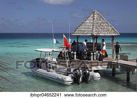 Stock Image - Top Dive Center, Divers preparing to dive, Inflatable Boat at the pier, Diving equipment, Sea, Pacific Ocean, KiaOra Resort & Spa, Rangiroa, Society Islands, Windward Islands, French Polynesia, Oceania. Fotosearch