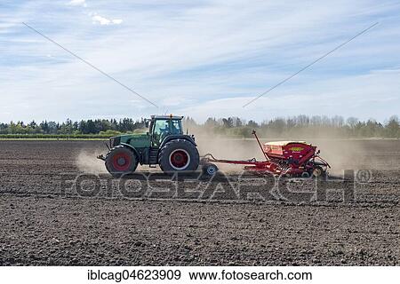 Stock Photo - Tractor with seed drill working a field in spring, Syddanmark, Denmark, Europe. Fotosearch