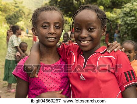 Stock Photo - Two girls, about 10 years old, smiling with a view into the camera, portrait, Ari tribe, Southern Nations Nationalities and Peoples' Region, Ethiopia, Africa. Fotosearch