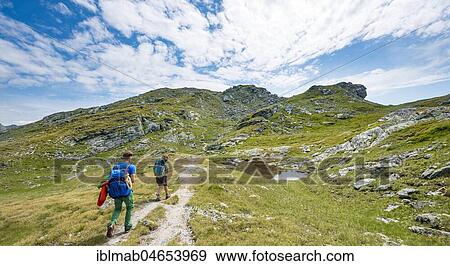 Two hikers at a small lake, Schladminger Höhenweg, Schladminger Tauern, Schladming, Styria, Austria, Europe View Large Photo Image Stock Photo - Two hikers at a small lake, Schladminger Höhenweg, Schladminger Tauern, Schladming, Styria, Austria, Europe. Fotosearch