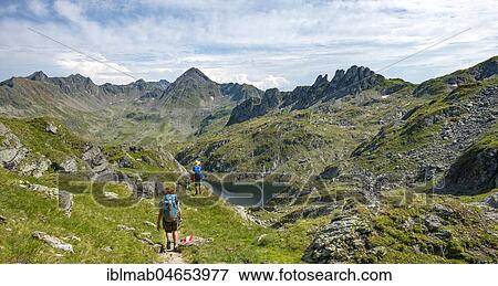 Stock Photo - Two hikers at Brettersee, Schladminger Höhenweg, Schladminger Tauern, Schladming, Styria, Austria, Europe. Fotosearch