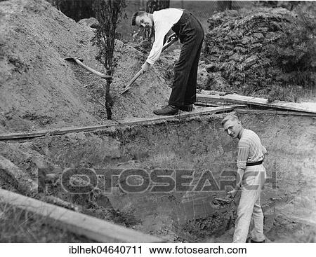 Stock Image - Two men digging a hole, 1940s, exact place unknown, Germany, Europe. Fotosearch