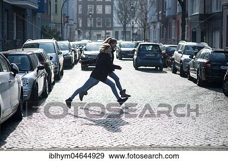 Two teenagers running across a street, Düsseldorf, North Rhine-Westphalia, Germany, Europe View Large Photo Image Stock Photo - Two teenagers running across a street, Düsseldorf, North Rhine-Westphalia, Germany, Europe. Fotosearch