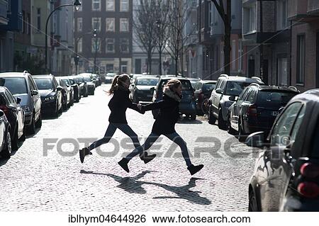 Two teenagers running across a street, Düsseldorf, North Rhine-Westphalia, Germany, Europe View Large Photo Image Stock Photograph - Two teenagers running across a street, Düsseldorf, North Rhine-Westphalia, Germany, Europe. Fotosearch