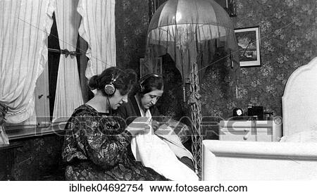 Two women listening to radio with headphones, stitching, 1930s, Germany, Europe View Large Photo Image Picture - Two women listening to radio with headphones, stitching, 1930s, Germany, Europe. Fotosearch
