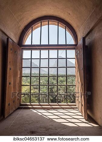 Stock Photo - View from barred window to palm oasis, fortress Nakhl, Nakhl, Oman, Oman, Asia. Fotosearch