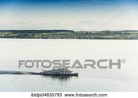 Stock Image - View of Lake Constance with excursion boat, in the back the Swiss Alps with Säntis, near Meersburg, Baden-Württemberg, Germany, Europe. Fotosearch