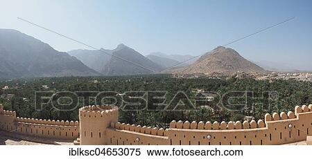 View over wall with battlements to palm oasis and Hajar Mountains, fortress Nakhl, Nakhl, Oman, Asia View Large Photo Image Stock Photography - View over wall with battlements to palm oasis and Hajar Mountains, fortress Nakhl, Nakhl, Oman, Asia. Fotosearch