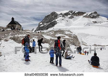 Stock Photograph - Visitors on Zugspitzplatt with chapel Maria Heimsuchung, Zugspitze, Bavaria, Upper Bavaria, Germany, Europe. Fotosearch