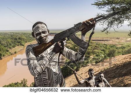 Warrior with rifle, Kalashnikov, AK47, Karo tribe, back Grandma River, Southern Nations Nationalities and Peoples' Region, Ethiopia, Africa View Large Photo Image Stock Image - Warrior with rifle, Kalashnikov, AK47, Karo tribe, back Grandma River, Southern Nations Nationalities and Peoples' Region, Ethiopia, Africa. Fotosearch