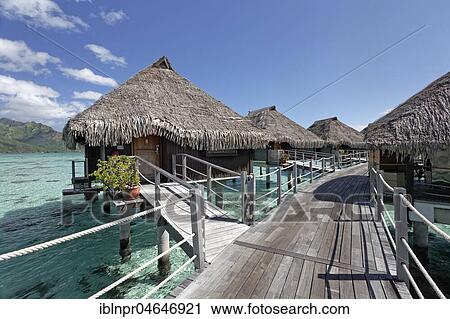 Stock Image - Water bungalows, walkway, Hilton Hotel, Moorea, Pacific Ocean, Society Islands, French Polynesia, Oceania. Fotosearch