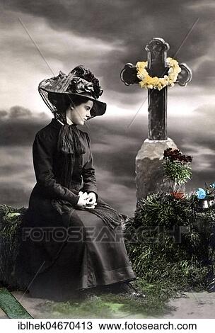 Stock Image - Widow mourns in front of a grave on the cemetery, 1910s, Germany, Europe. Fotosearch