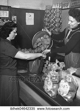 Stock Photography - Woman buys potatoes, 1960s, Germany, Europe. Fotosearch