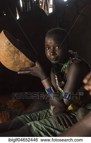 Stock Photograph - Woman drinking from calabash, sitting in mud hut, Hamer tribe, Turmi, region of the southern nations, Ethiopia, Africa. Fotosearch